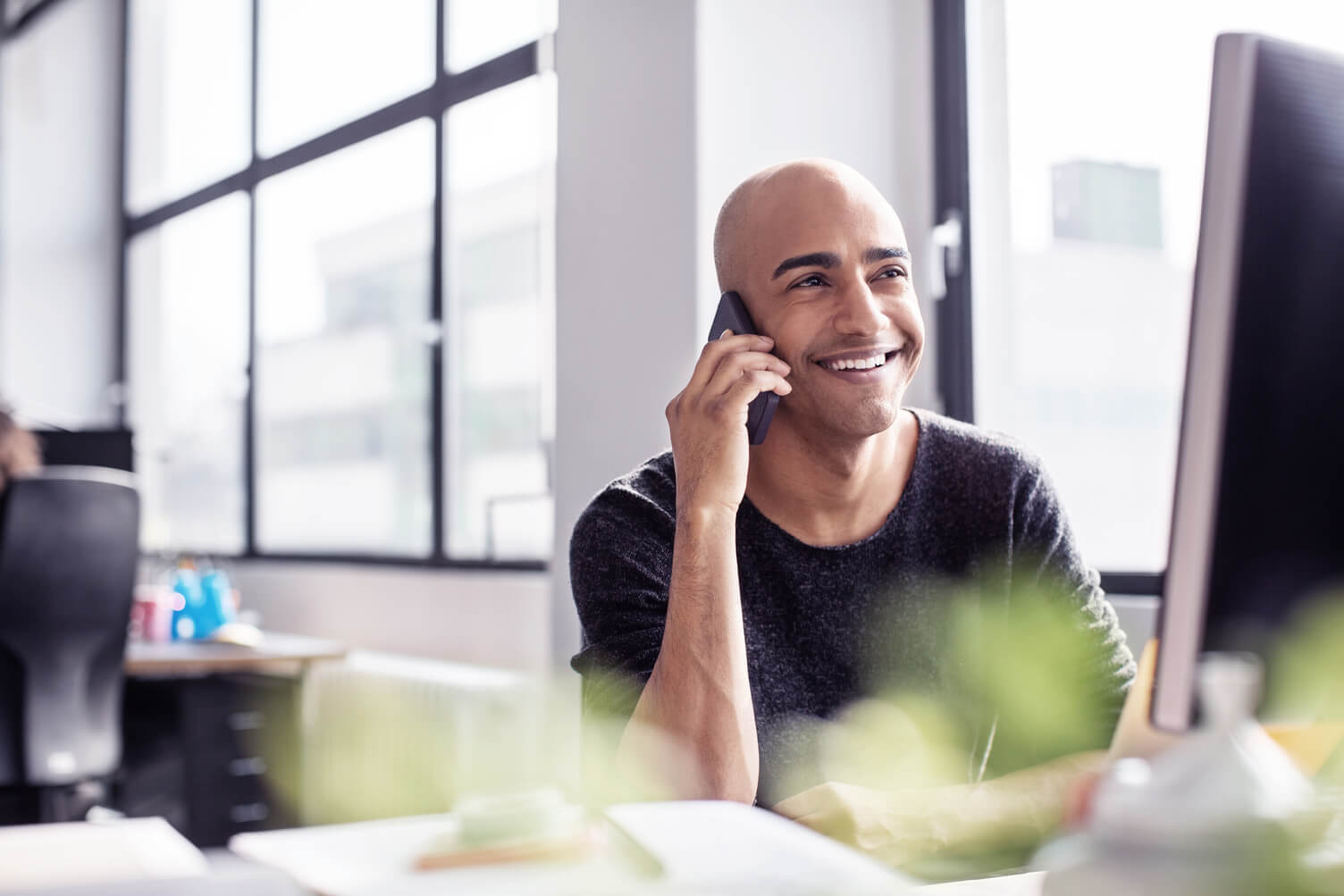 Company owner at his desk, discussing workforce management options during a corporate conference call