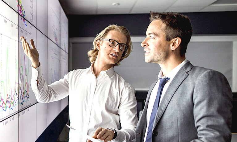 Colleagues reviewing data on whiteboard