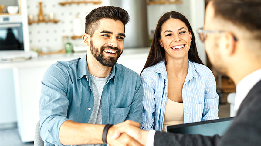 couple meeting with businessman shaking hands