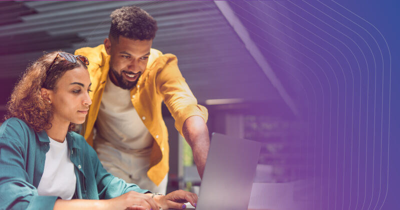 two coworkers looking at a computer together