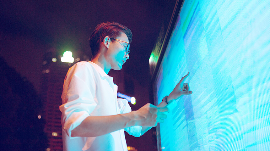 asian man working on large digital screen