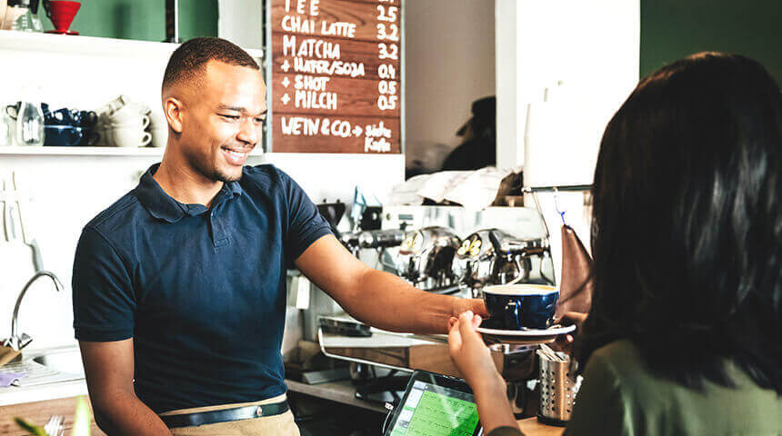 Barista passing coffee to customer