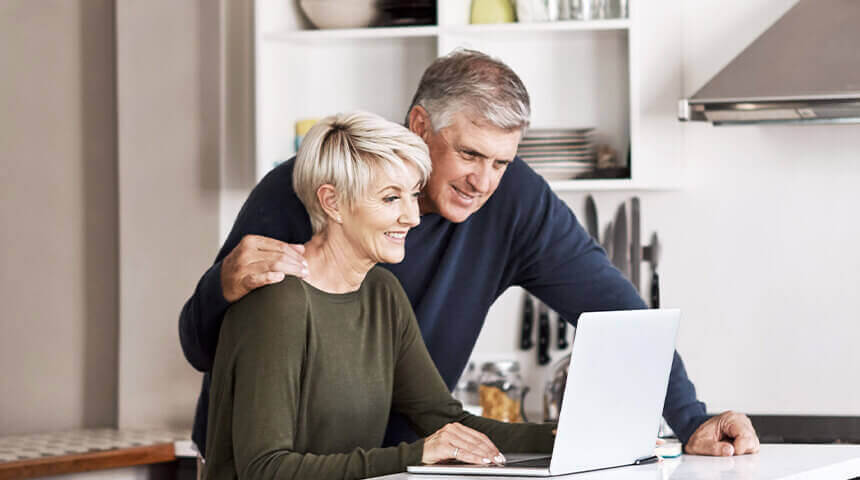 Couple looking at laptop in kitchen