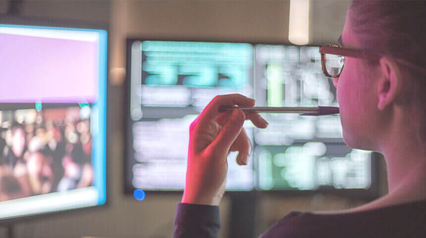 Person with pen looking at computer