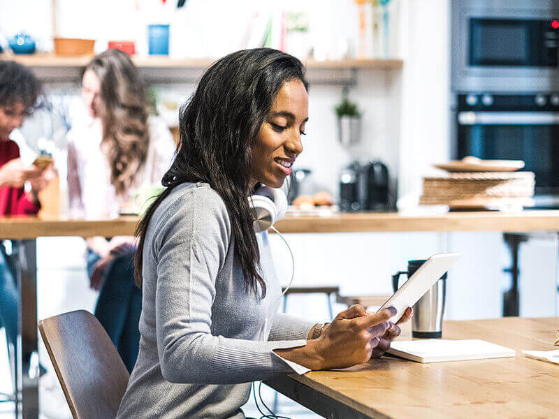 smiling woman using tablet at table