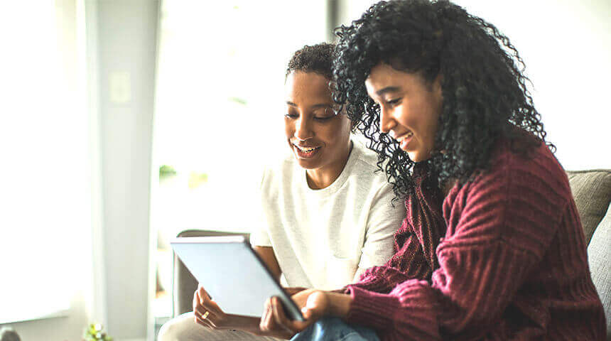 Two people looking at tablet talking