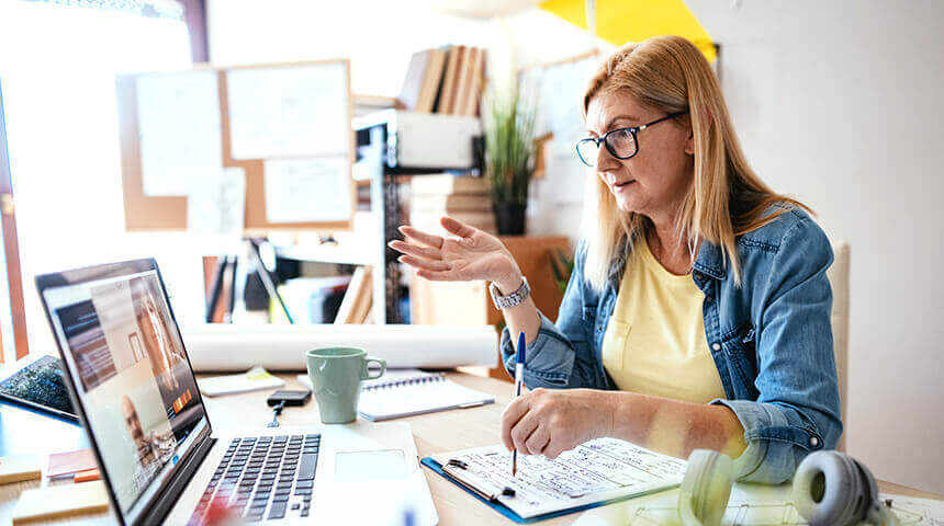 Woman sitting at desk attending web conference