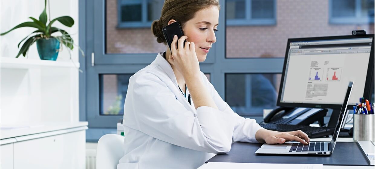 doctor on the phone looking at computer