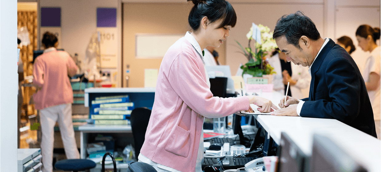 man checking in at hospital desk