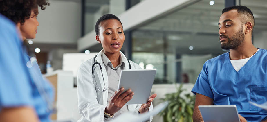 group of medical professionals reviewing a tablet