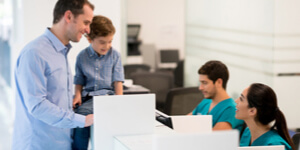 father and son at hospital front desk