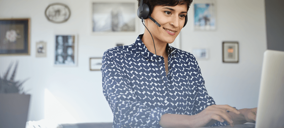 woman wearing headset looking at laptop